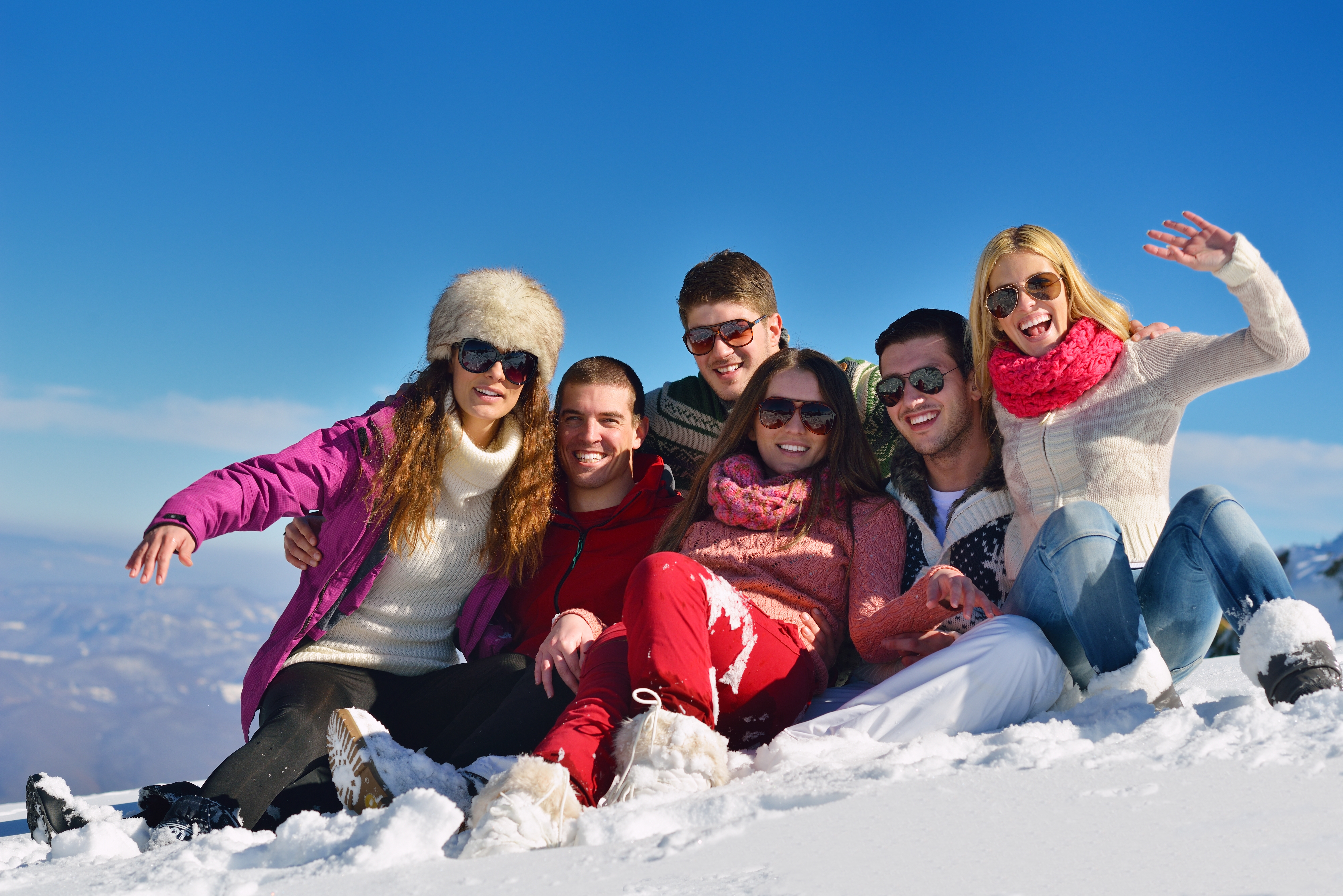 happy young people group have fun and enjoy fresh snow at beautiful wi
